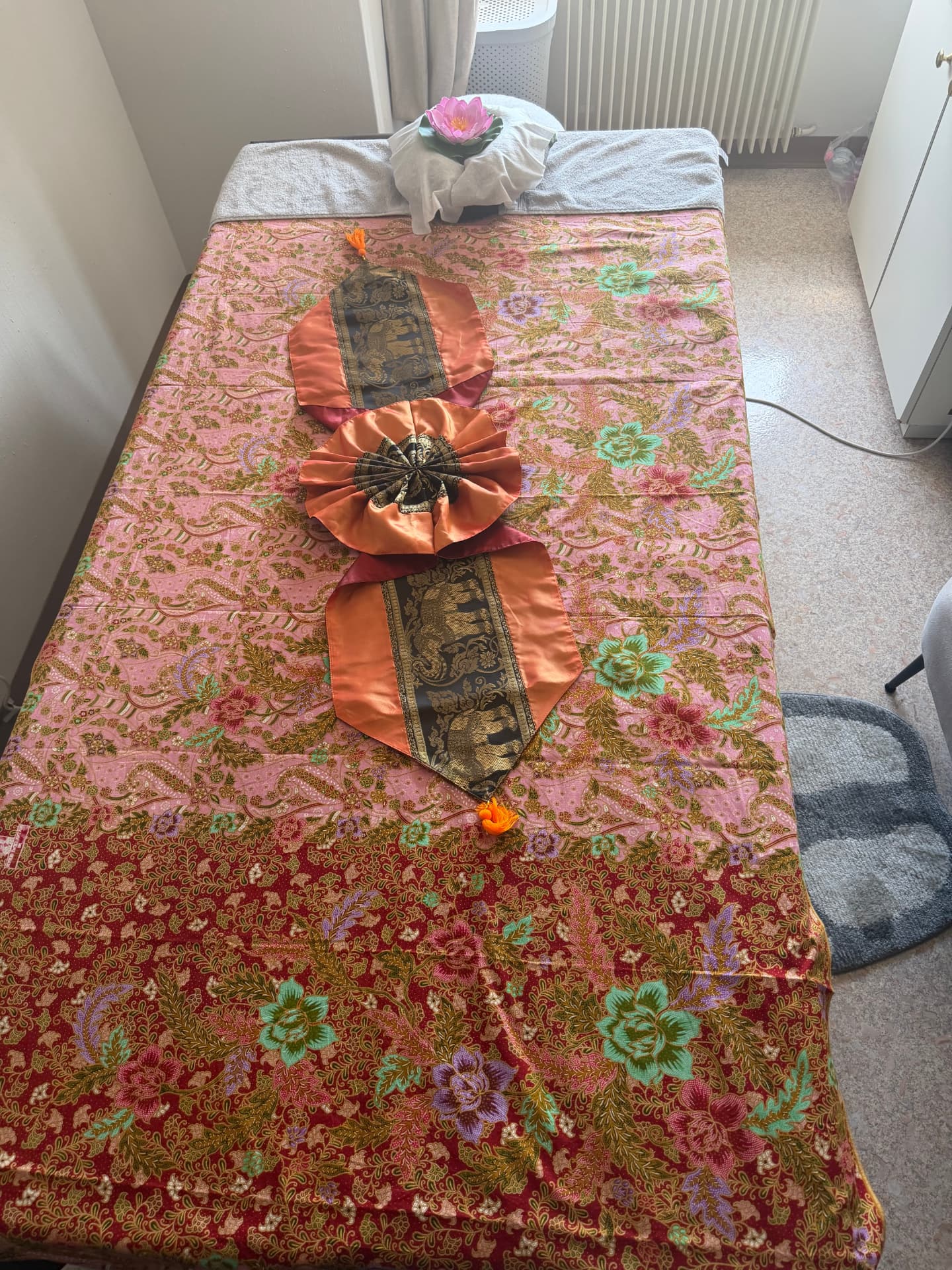 Massageliege mit traditionellem Thai Stoff und Lotusblüte